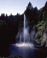 Tranquil Waters. A Scenic View of a Serene Lake Surrounded by Lush Greenery and a Majestic Waterfall photo