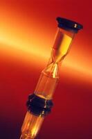Hourglass Against Fiery Background Representing Time Passage photo