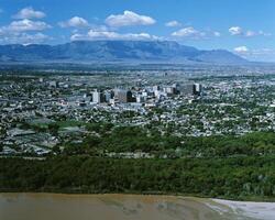 Majestic Urban Skyline Against a Clear Blue Sky and Mountainous Backdrop photo