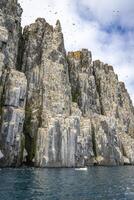 rocks waterfall and glacier at the Alkefjellet between Spitsbergen and Nordaustlandet on Svalbard, Norway photo