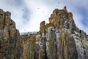 rocks waterfall and glacier at the Alkefjellet between Spitsbergen and Nordaustlandet on Svalbard, Norway photo
