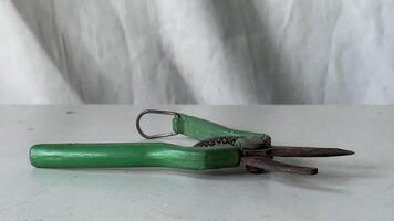 Vintage green scissors resting on a simple white surface indoors photo