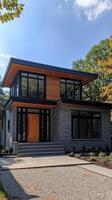 Modern suburban house with cedar siding and stone cladding on sunny day photo