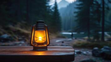 Kerosene lamp glowing on wooden table in misty forest at dusk photo