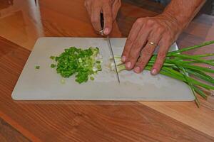 Chopping green onions for salad. photo