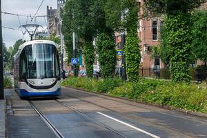 A tram, a public transport vehicle, in motion on rails. photo