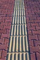 Tactile pavement for the disabled and blind, texture on tiles for the disabled, selective focus, pedestrian path. photo