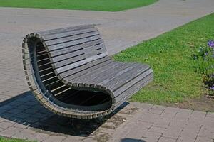 Rest bench in the park. A bench in the park against the background of grass and paths. photo