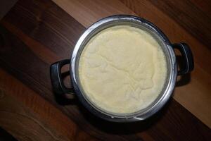 A layer of cream formed on milk boiled in a saucepan. photo