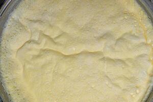 A layer of cream formed on milk boiled in a saucepan. Close-up. photo