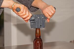 Woman using a cap to attach metal lids to beer bottles. photo