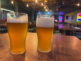 Two glasses of beer on the table in the pub. photo