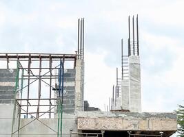 Building Construction Site with Scaffolding, Steel Structures, Material Piles, and Construction Equipment photo