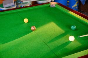 Man's hand playing snooker in bar with snooker ball photo
