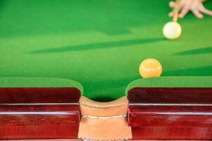 Man's hand playing snooker in bar with snooker ball photo