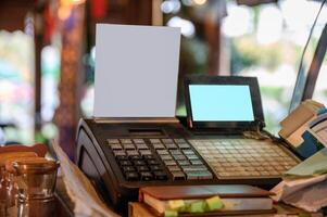 Cashier counter with digital screen and white label on wooden table photo