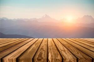 Brown wooden table top on blurred peak on mountain range with sunrise photo