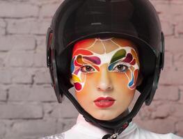 Model with bright creative make up with helmet photo