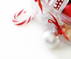 a clear plastic container with candy canes and ornaments photo