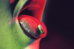 Close-Up of Pill on Tongue in Neon Light photo