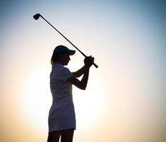 Female golfer at sunset photo