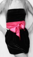a woman in a black dress with a pink belt photo