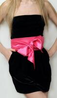 a woman in a black dress with a pink ribbon photo