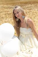 Smiling girl with white balloons photo