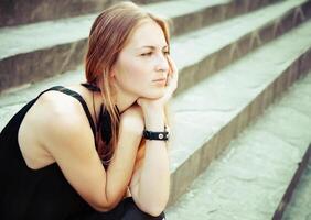 Portrait of the beautiful blond woman on the stairs photo