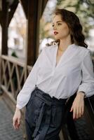 Elegant businesswoman leaning on wooden railing in urban setting photo