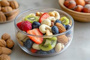 Colorful fruit and nut mix served in glass bowl with other nuts on the table photo