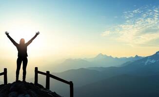Person practices yoga at mountain peak during sunrise with raised arms for tranquility and peace photo