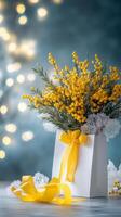 Bright yellow flowers in a white gift box with a ribbon on a blurred background photo