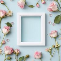 Floral decoration with white frame and pastel roses on soft blue background photo