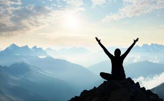 Person practices yoga at mountain peak during sunrise with raised arms for tranquility and peace photo
