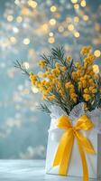 Bright yellow flowers in a white gift box with a ribbon on a blurred background photo