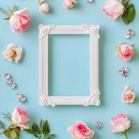 Floral decoration with white frame and pastel roses on soft blue background photo
