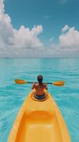 Bright yellow canoe floating on clear blue water under a sunny sky in a tropical paradise photo
