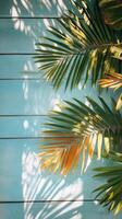 Palm leaves casting shadows on a blue wooden background in bright daylight photo