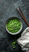 Fresh edamame in bowl with chopsticks on dark surface ready for a nutritious snack photo