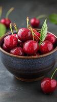 Fresh cherries in a clear glass bowl on a light background photo