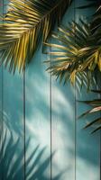 Palm leaves casting shadows on a blue wooden background in bright daylight photo