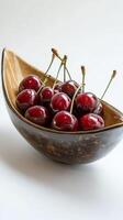 Fresh cherries in a clear glass bowl on a light background photo