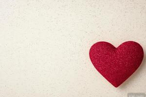 Heart shape painted on textured surface with splashes of red and white in background photo