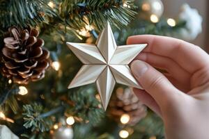 Delicately placing a star ornament on a snow-covered Christmas tree in warm holiday light photo
