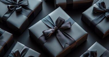 Decorative black gift boxes with satin bows arranged elegantly on a dark surface photo
