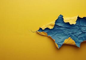 Colorful torn paper revealing a vibrant blue section against a bright yellow background photo