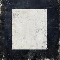 Abstract art composition emphasizing a textured black and white square on a weathered surface photo