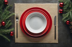 Elegant holiday dining setup featuring red dishes and festive decorations on a table photo