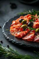 Deliciously arranged cured meats and olives on a dark slate platter for an elegant appetizer photo